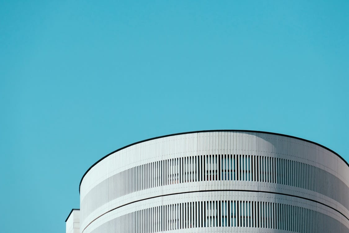 Contemporary curved office building against a clear blue sky